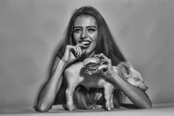 Жінка з бургер і свиня — стокове фото
