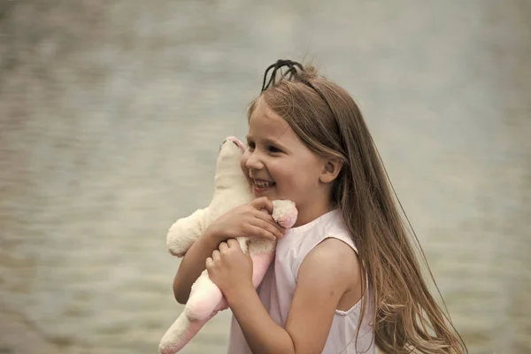 Lány hosszú haj mosoly a puha játék — Stock Fotó