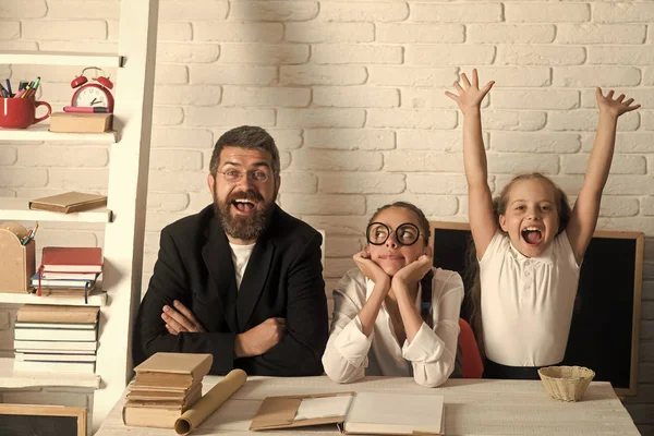 Mädchen und bärtiger Mann sitzen mit Büchern am Schreibtisch — Stockfoto