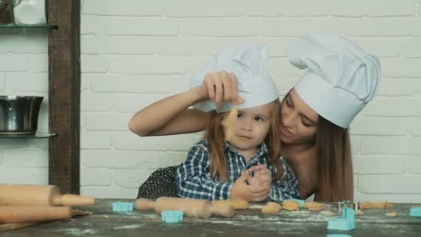 Mutlu aile birlikte fırın hazırlıyor. Anne ve kız çocuk kurabiye pişiriyor ve mutfakta eğleniyorlar. Ev yapımı yemek ve küçük bir yardımcı.. — Stok video