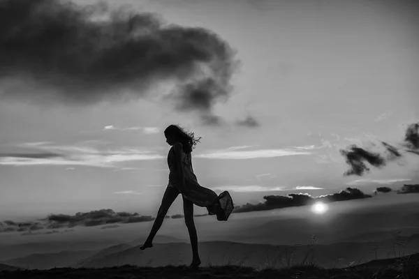 Mujer al atardecer o al amanecer en las montañas — Foto de Stock