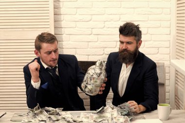 İş ortakları, office toplantıda işadamları. Thoughtfull yüz kavanoz ile meslektaşları para tam. Para ve bankacılık kavramı. İş kar, kavanoz veya banka hesabı para tutmak.