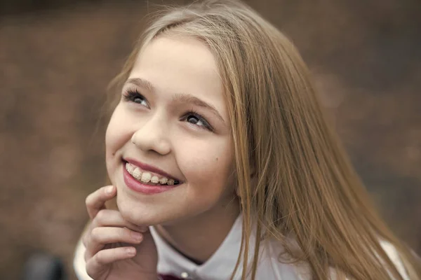 Sorriso ragazza con viso carino, bellezza. Bambino piccolo sorridente con lunghi capelli biondi, acconciatura outdoor. Bellezza del bambino, capelli e look. Buona infanzia e giovinezza. Concetto di cura della pelle e dei capelli — Foto Stock