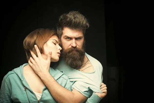 Foto de moda de pareja tras corte de pelo. Concepto de peinado. Hombre con barba elegante y bigote y chica con corte de pelo fresco, nuevo peinado. Mujer en cara misteriosa con hombre barbudo, fondo negro . — Foto de Stock