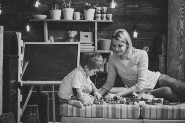 Evde Oluşturucu ile aile oynamak. Anne ve çocuk Oluşturucu, plastik tuğla ayrıntıları ile oynamak. Anne ve oğlu Oluşturucu ile oynamak. Çocukluk kavramı. Kara tahta arka plan ile kreş.