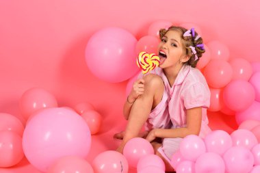 Parti balonları, çocukta curlers, pijama moda. Çocukluk, mutluluk, tatlı rüyalar. Küçük kız candy lolipop ile. Küçük kız çocuk üzerinde pembe lolipop yemek. Diyet, doğum günü, punchy pastel, güzellik.