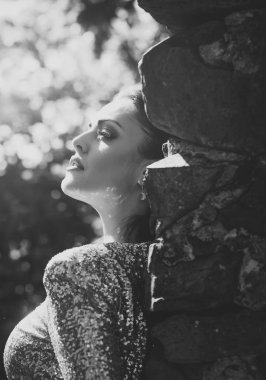 Kadın taş duvara güneşli günde poz