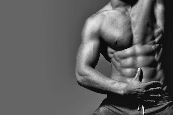 Los hombres curan el cuidado corporal. hombre con musculoso sexy cuerpo y seis paquetes en torso en pantalones en estudio . — Foto de Stock