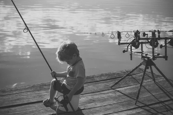Милый мальчик рыбачит на реке — стоковое фото