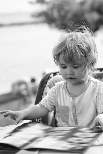 Милый мальчик читает меню — стоковое фото