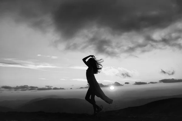 Mujer al atardecer o al amanecer en las montañas — Foto de Stock