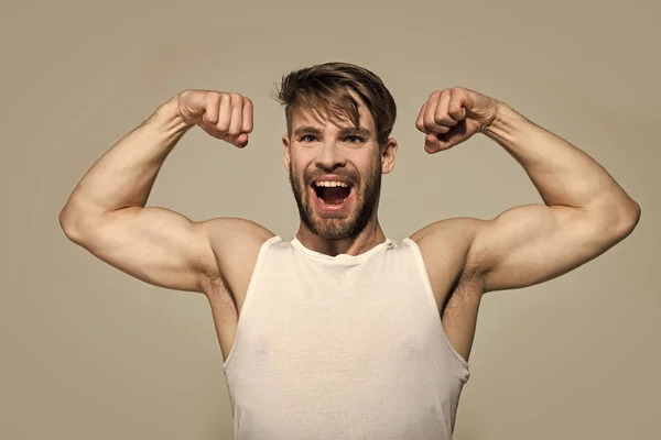 Gelukkig man flex spieren, de biceps, de triceps op grijze achtergrond — Stockfoto