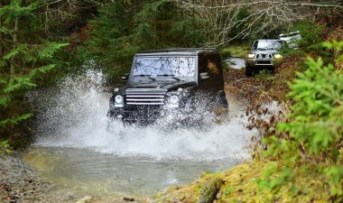 Dere ile yolda yarış araba. Extreme sürüş, rekabet ve 4 x 4 Araçlar kavramı. Orman Offroad yarış. Suv ya da offroad araba su akışı geçiş