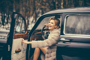 moda ve retro tarzı, moda modeli kış kürk paltolu retro araba kullanıyor