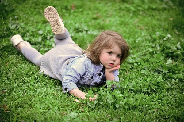 Little girl on green grass in park — Stock Photo, Image