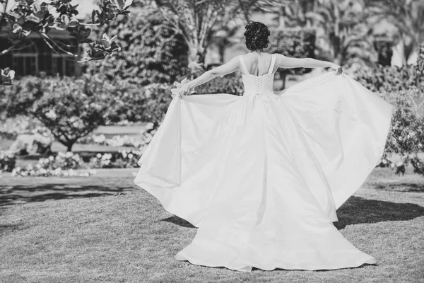 Woman waving wedding dress as wings — Stock Photo, Image
