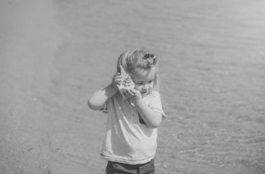 Çocuk dinle seashell için güneşli günde