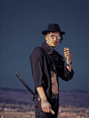 Koyu mavi gökyüzü üzerinde katana kılıcı duran adamla