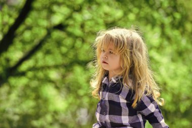 Açık ekose gömlekli uzun sarı saçlı çocuk