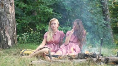 Müzik çalma ve doğada şenlik ateşi zevk mutlu arkadaşlar. Gençler eğleniyor orman. Ormanda oturan arkadaşlar bir kamp ateşi daire.