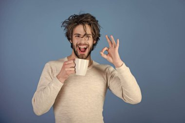 Adam kameraya bakıyor. Sabah kahve veya süt ile.