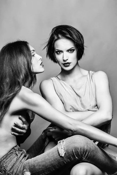 Zwei stylische hübsche Frauen, die sich in Beziehungen umarmen — Stockfoto
