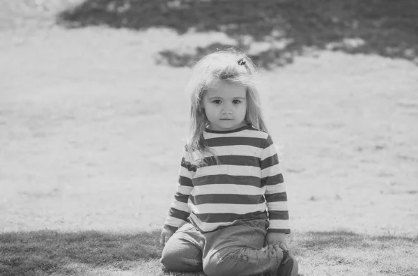 Enfant assis sur une pelouse verte — Photo