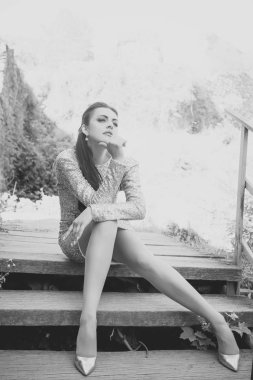 Kadın yüz güzellik. Ahşap merdivenlerde oturan yüksek topuklu ayakkabılar kadında