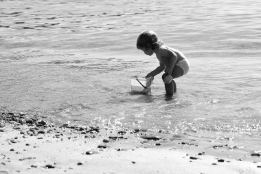 Mutlu bir çocukluk eğleniyor. Kumsalda oynarken çocuk