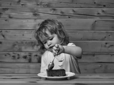 Mutlu bir çocukluk eğleniyor. Küçük çocuk meyveli kek yiyor