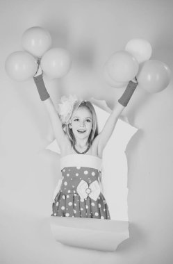 Mutlu bir çocukluk eğleniyor. Küçük modern retro kız moda giysileri tutun balonlar.