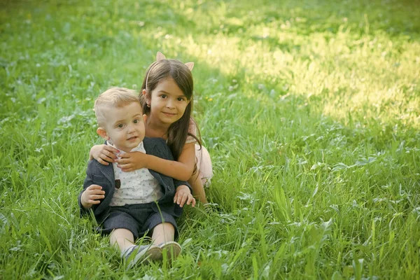 幸せな子供の楽しい時を過します。家族、子供、兄弟と緑の草の上の妹 — ストック写真