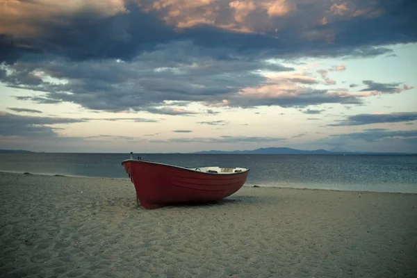 Bateau de pêcheurs au bord de la mer, sur le sable au coucher du soleil avec horisont mer sur fond. Concept de voyage et de repos. Fond de mer avec des vagues et ciel avec des nuages après la tempête. Bateau de pêche sur la plage le soir — Photo