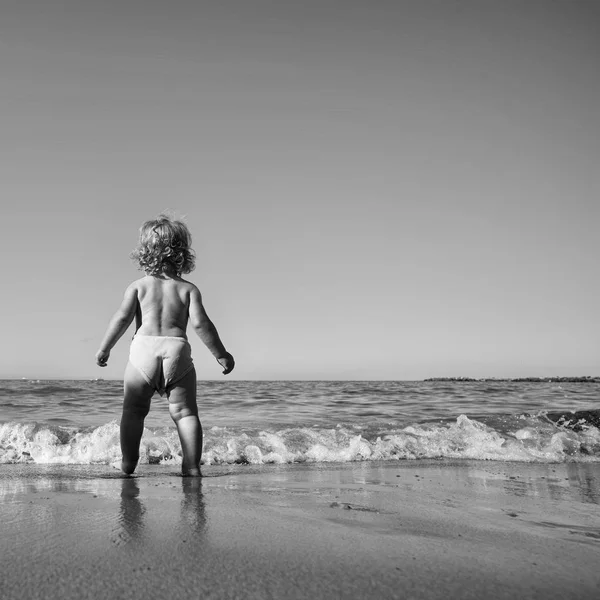Glückliches Kind, das Spaß hat. Junge läuft auf See — Stockfoto