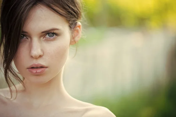 Mulher enfrenta a beleza. Mulher posando em fundo natural turvo — Fotografia de Stock