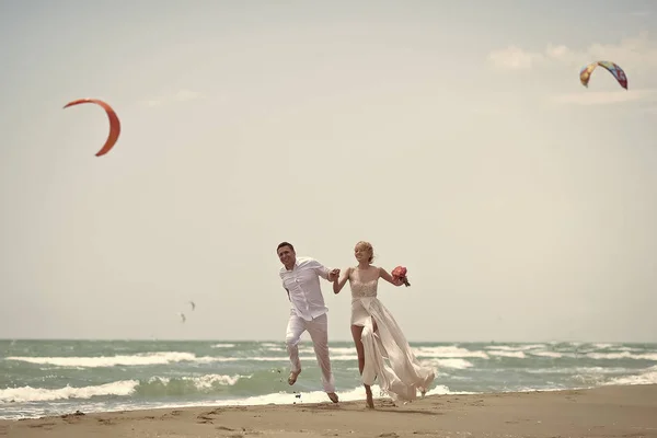 Casal apaixonado beijando, menino e menina. Saltando casal de casamento na praia — Fotografia de Stock