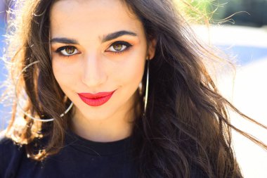 Gülümseyen güzel kadın dışarıda eğleniyor. Doğal zemin, mutluluk kavramı üzerine tam kırmızı dudaklar ile hanımefendi.