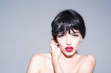 Şehvetli kadın tam kırmızı dudaklar ve gri arka plan üzerinde izole kanatlı göz kalemi ile. Mükemmel makyaj üstsüz poz, femme fatale, baştan çıkarma kavramı ile seksi kız.