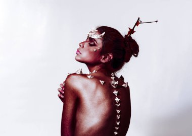 İblis dikenli kırmızı deri üzerinde omurga boyunca. Beyaz arka plan üzerinde izole sanatsal vücut makyajlı kız. Büyülü yaratık, fantezi kavramı doğanın ruhu tasvir topuz koyu saçlı kadın.