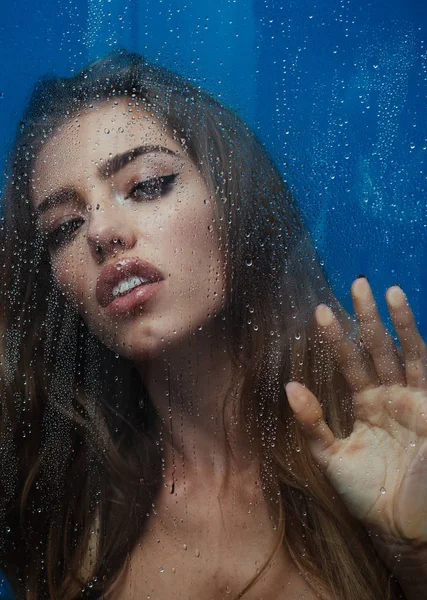 Genç kadının fotoğrafını ağlayan cam duş kapı üzerinde çizer, pislik içinde kalan sahiptir, vücudu yıkar, su damlaları ile buhar bulanık cam arkasında duruyor. Banyo dinlenme