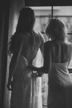 Bayan sırları. Güzel gelinin nedimesi gelinlik üzerinde koymak için güzel gelin yardımcı olur.