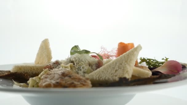 Köstlicher Snack aus Schlagpüree oder Paste mit braunem Brotstück, mit karamellisiertem Zucker, Salat, Gemüse auf Teller auf weißem Hintergrund. moderne molekulare Gastronomie — Stockvideo