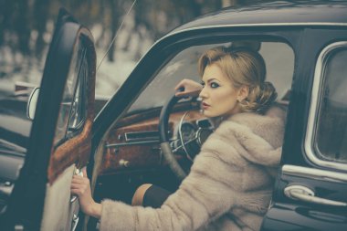 seksi kadın kürk paltolu. Eski model araba içinde telekız. Seyahat ve iş gezisi ya da hiking hitch. Retro koleksiyonu araba ve otomatik sürücü tarafından onarın. Escort ve güvenlik görevlisi lüks kadın için.