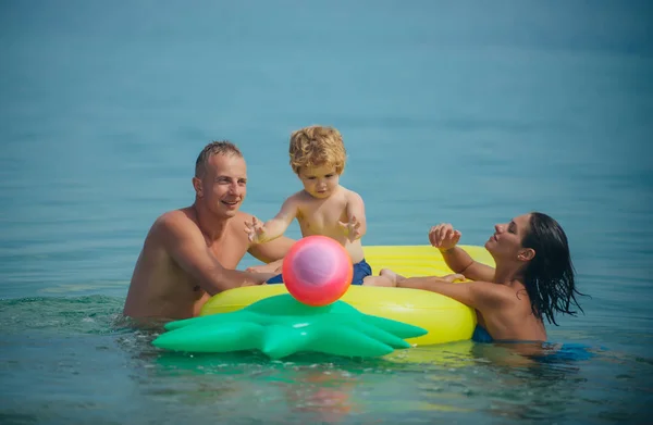 夏休み 海への旅行 父と息子と母は 水でボールをプレーします パイナップル インフレータブルまたはエアコンのマットレス モルディブまたはマイアミ ビーチ活動の喜び カリブの海に幸せな家族カップル — ストック写真