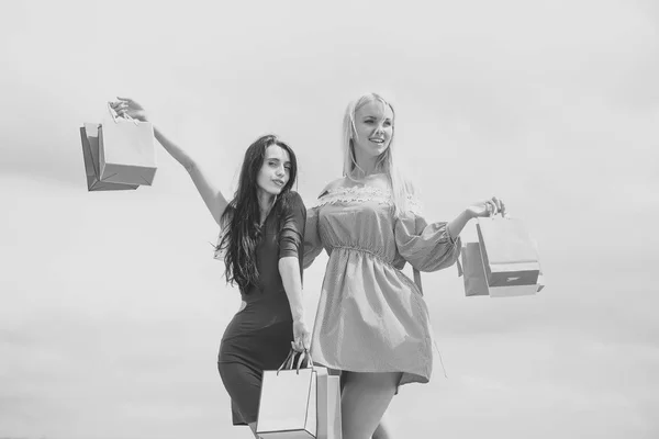 Sexy paar. Meisjes in trendy jurken houden boodschappentassen — Stockfoto