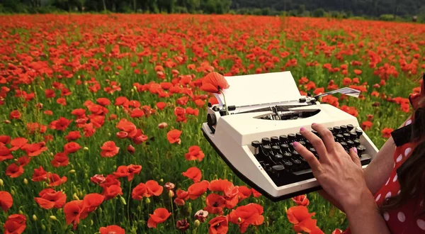 Orange vintage skrivmaskin med en hand på författare. — Stockfoto