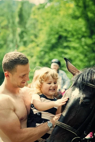 Glückliches Kind, das Spaß hat. Mädchen mit Mann Haustier Pferd an sonnigen Tag — Stockfoto