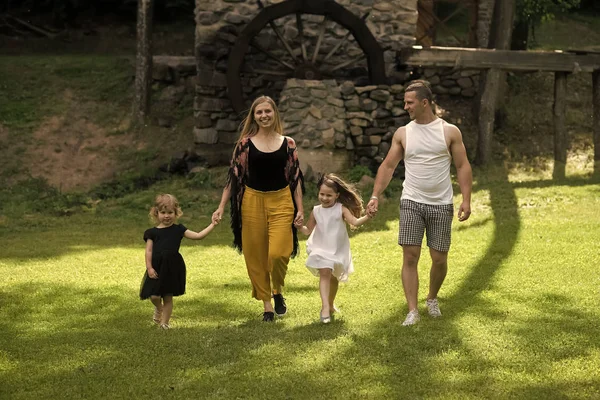 Kind Kindheit Kinder Glückskonzept. Kinder und Eltern laufen auf grünem Gras — Stockfoto