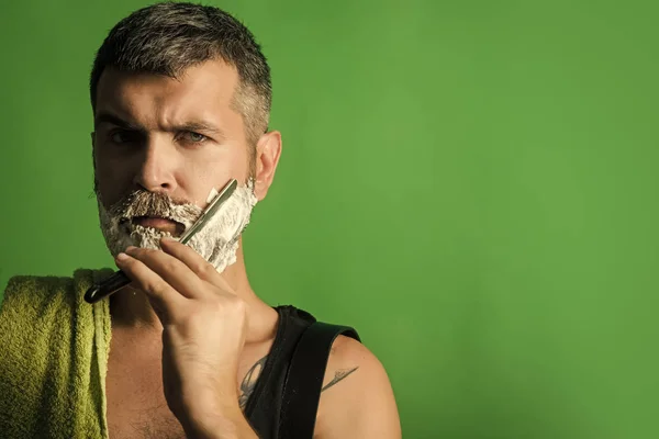 Man gezicht knap. Ernstige hipster in barbershop en nieuwe technologieën. — Stockfoto