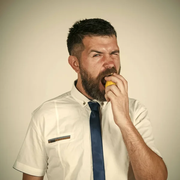 Mens geneest zorg. Man met lange baard eet citroen. — Stockfoto
